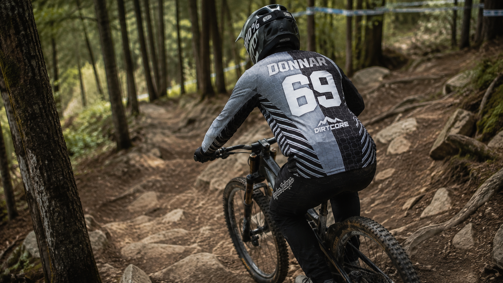 Downhill-Fahrer im Grey-Split-Jersey mit DONNAR 69 und DIRTCORE